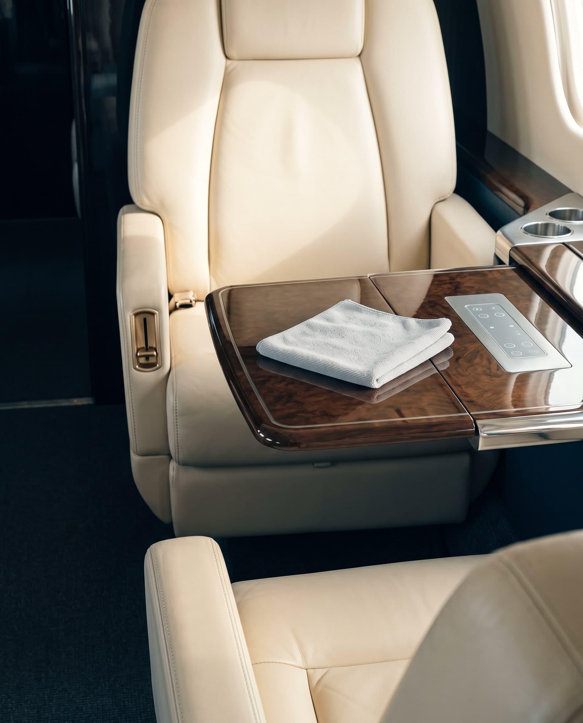 Close detail of an immaculate jet cabin's leather, tray table and controls after disinfection